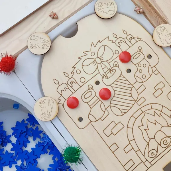 Zoom sur un plateau éducatif en bois gravé représentant une cheminée de Noël avec chaussettes suspendues, bougies et jetons rouges – activité Montessori