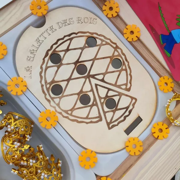 Plateau sensoriel en bois gravé représentant une galette des rois avec jetons et couronnes dorées, activité Montessori sur le thème de l’Épiphanie