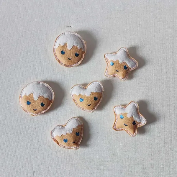 Petits biscuits d’hiver en feutrine cousus main avec glaçage blanc et visages souriants pour activité Montessori