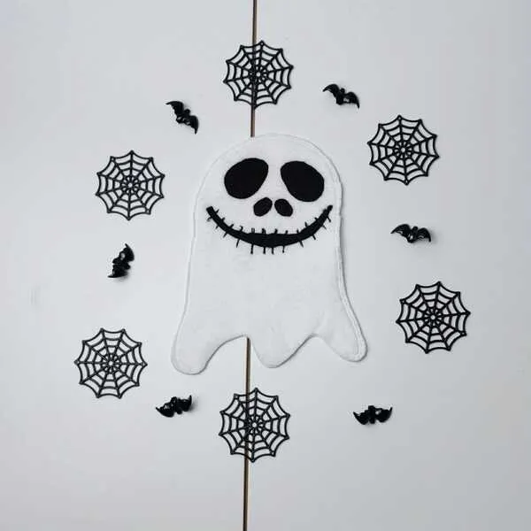 Fantôme en feutrine blanche décoré de motifs noirs, entouré de toiles d’araignée et petites chauves-souris.