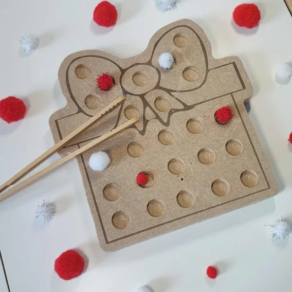 Activité Montessori de motricité fine avec plateau en bois MDF en forme de cadeau de Noël, pompons rouges et blancs et baguettes d’apprentissage