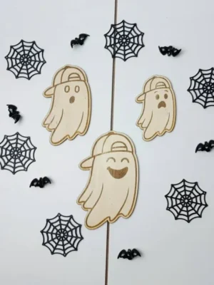 Ensemble de trois fantômes en bois avec casquette, chacun portant une expression différente, entourés de toiles d’araignée noires et de petites chauves-souris décoratives.