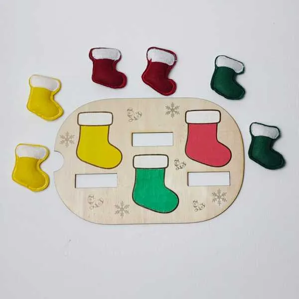 Plateau en bois illustré de bottes de Noël colorées avec des bottes en feutrine assorties disposées autour pour une activité de tri des couleurs.
