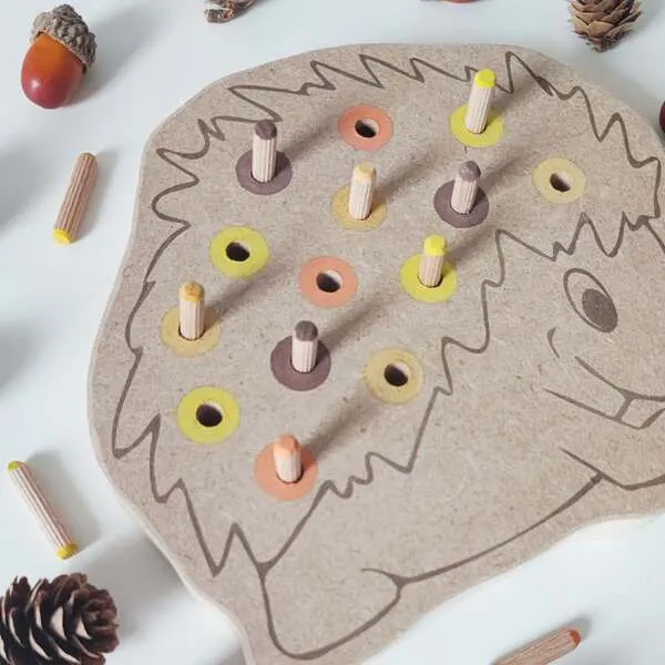Plateau hérisson en bois avec pics colorés insérés, activité de motricité fine et tri des couleurs pour enfant