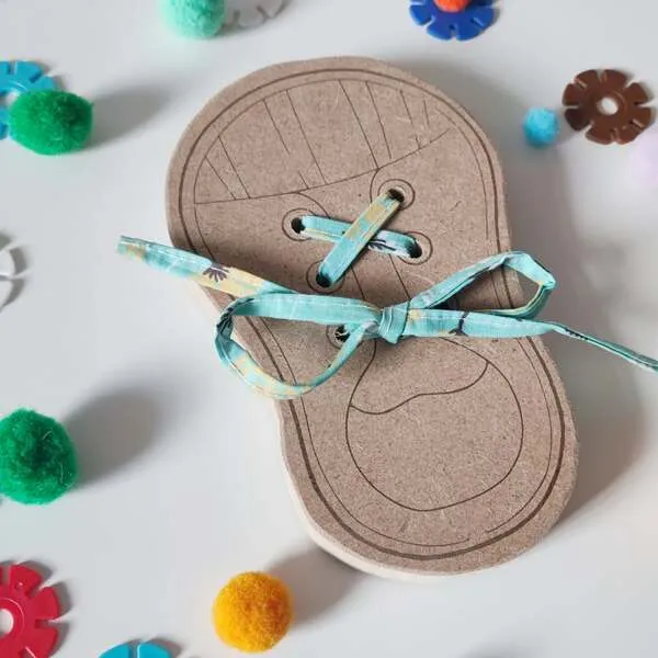 Gros plan sur carte de laçage en bois avec lacet, activité de motricité fine pour enfant