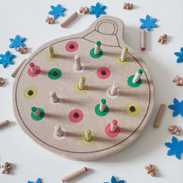 Détail du plateau de motricité fine boule de Noël en bois avec pics colorés à insérer, activité éducative enfant