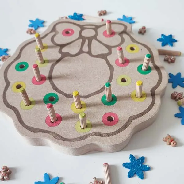 Détail du plateau de motricité fine couronne de Noël en bois avec pics colorés à insérer