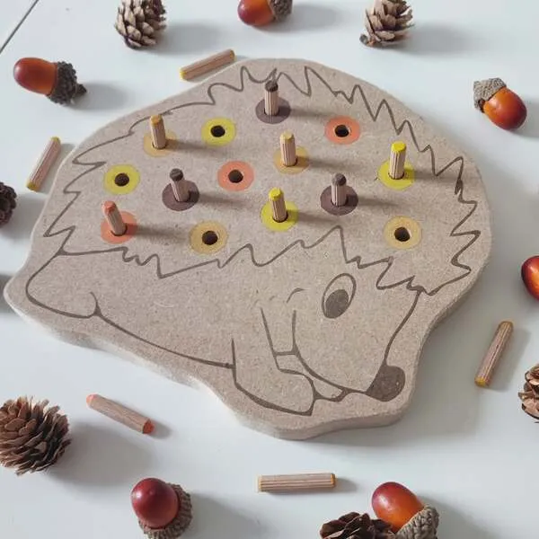 Détail du plateau de motricité fine hérisson en bois avec emplacements colorés et pics à insérer pour enfant