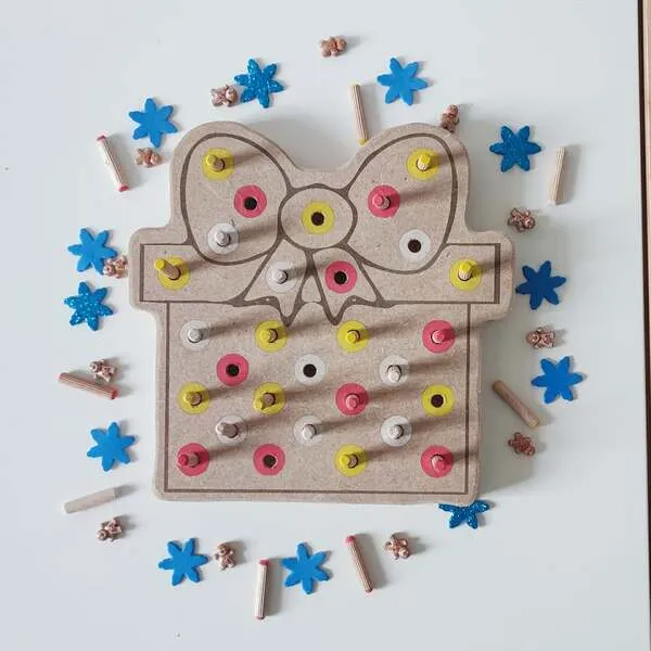 Plateau de motricité fine en bois en forme de cadeau de Noël avec nœud et pics colorés à insérer
