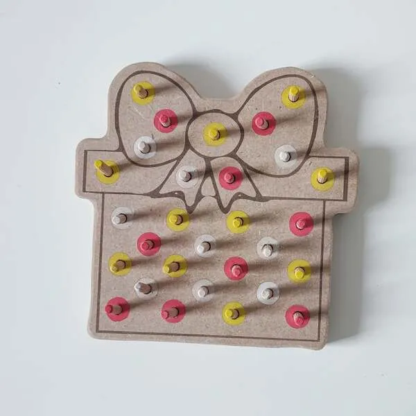 Plateau de motricité fine en bois en forme de cadeau de Noël avec nœud et pics colorés
