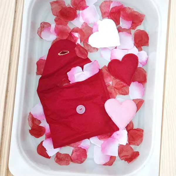 Pochettes en feutrine en forme de cœur avec cœurs assortis dans un bac sensoriel sur le thème de la Saint-Valentin