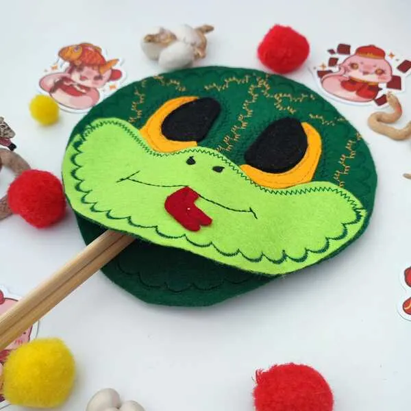 Masque de serpent en feutrine verte sur bâtonnet, activité sensorielle thème Nouvel An chinois avec pompons colorés
