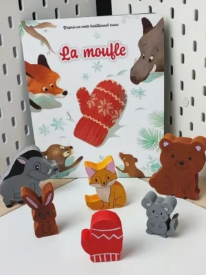 Figurines en bois du conte La moufle avec animaux et moufle rouge devant l’album jeunesse