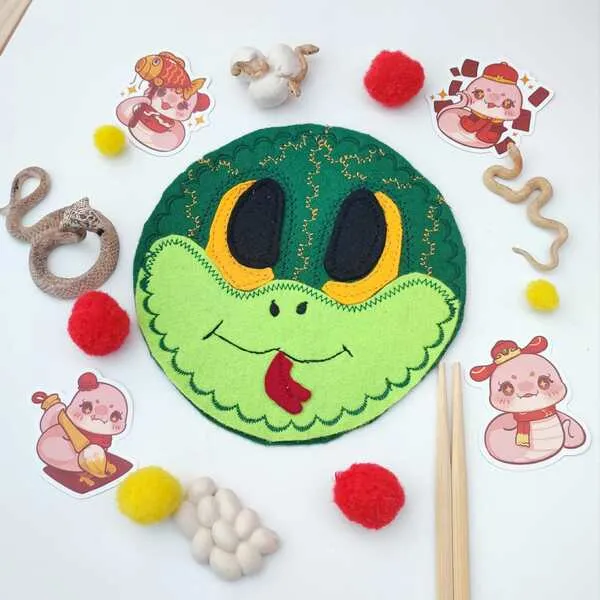 Masque serpent en feutrine verte avec pompons rouges et jaunes, accessoires sensoriels et décor Nouvel An chinois