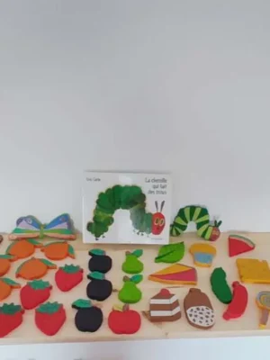 Jeu éducatif chenille en bois avec aliments inspiré de La chenille qui fait des trous.