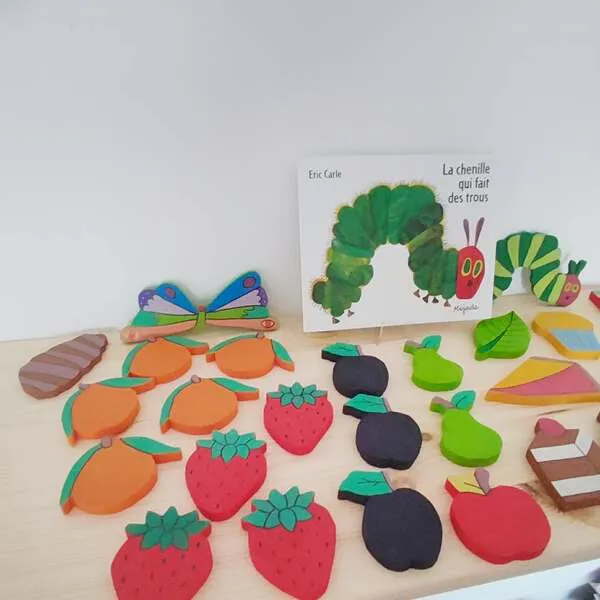 Jeu chenille en bois avec fruits colorés et livre La chenille qui fait des trous.