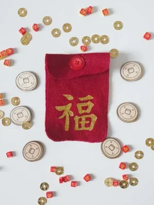 Pochette rouge en feutrine Nouvel An chinois avec symbole de chance, accompagnée de pièces dorées et jetons pour jeu sensoriel enfant