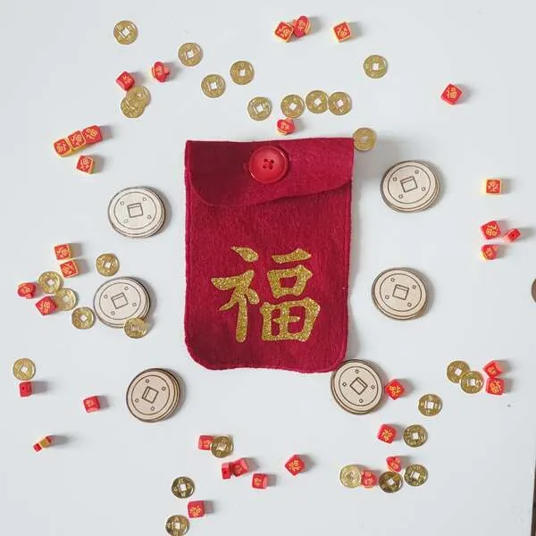 Pochette rouge en feutrine Nouvel An chinois avec symbole de chance, accompagnée de pièces dorées et jetons pour jeu sensoriel enfant