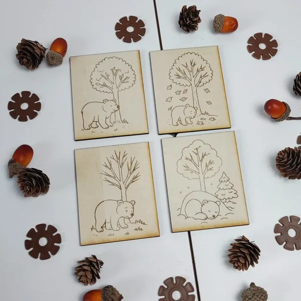 Cartes en bois gravées représentant un ours à travers les saisons dans un décor forestier
