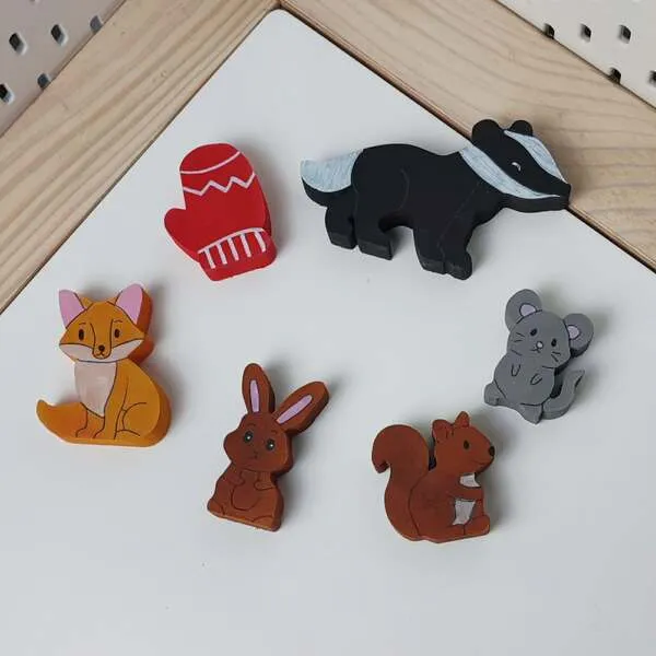 Figurines en bois du conte La moufle disposées à plat sur fond clair