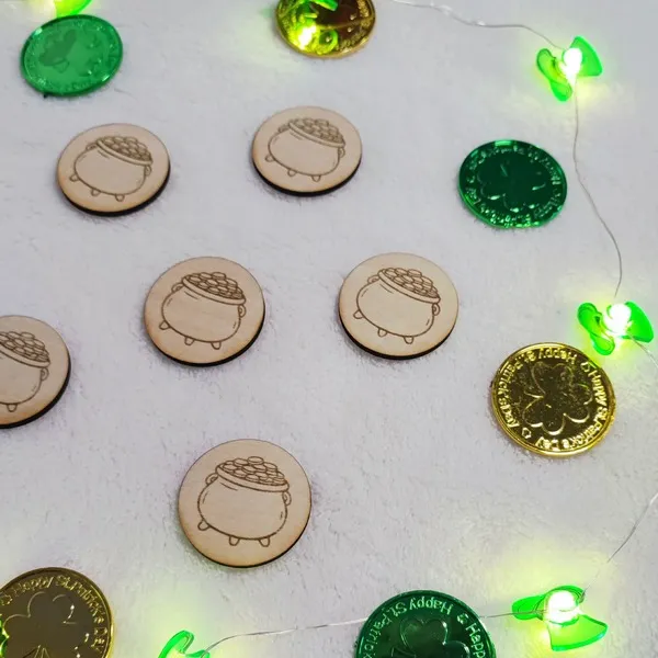 Jetons en bois gravés chaudron d’or disposés pour activité thème Saint Patrick.