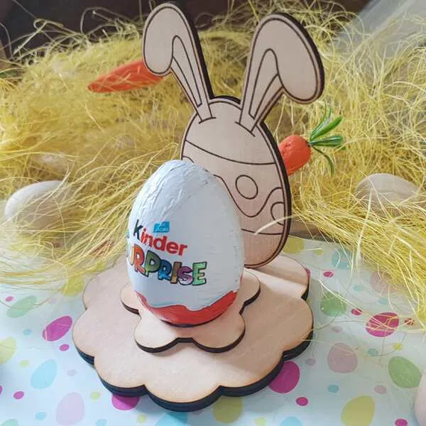 Support en bois pour œuf de Pâques avec silhouette de lapin et œuf décoré, présentant un œuf en chocolat posé sur un socle fleur.