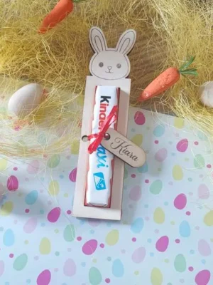 Support en bois lapin personnalisé contenant une barre de chocolat, présenté dans une décoration de Pâques