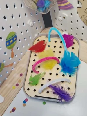 Plateau de motricité fine en bois avec plumes colorées et chenilles thème carnaval