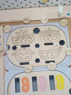 Plateau d’activité en bois sur le thème du carnaval avec masques gravés et jetons à manipuler pour la motricité fine