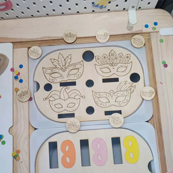 Plateau d’activité en bois sur le thème du carnaval avec masques gravés et jetons à manipuler pour la motricité fine