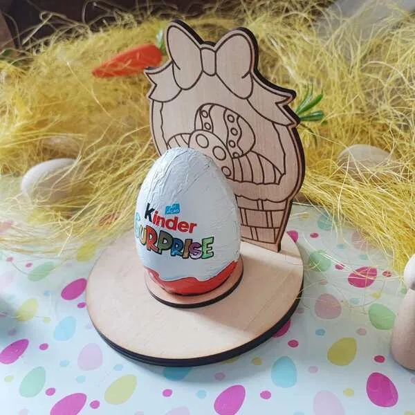 Présentoir en bois pour œuf de Pâques représentant un panier gravé avec grand nœud, posé sur un socle rond avec œuf en chocolat.
