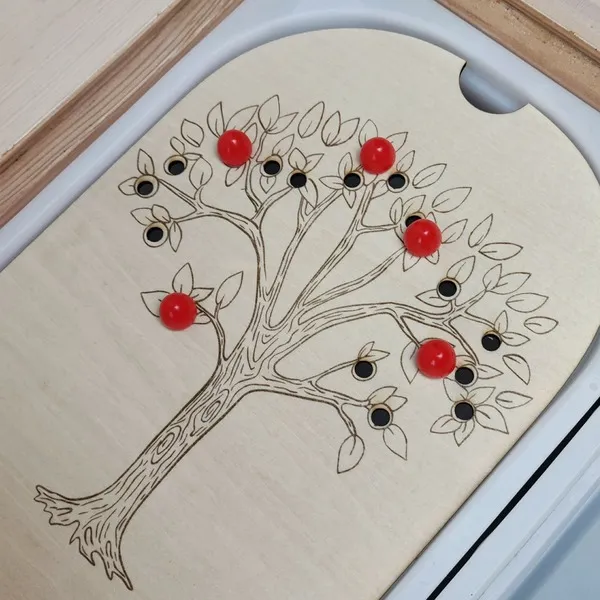 Plateau de motricité fine en bois arbre avec billes rouges positionnées sur les branches