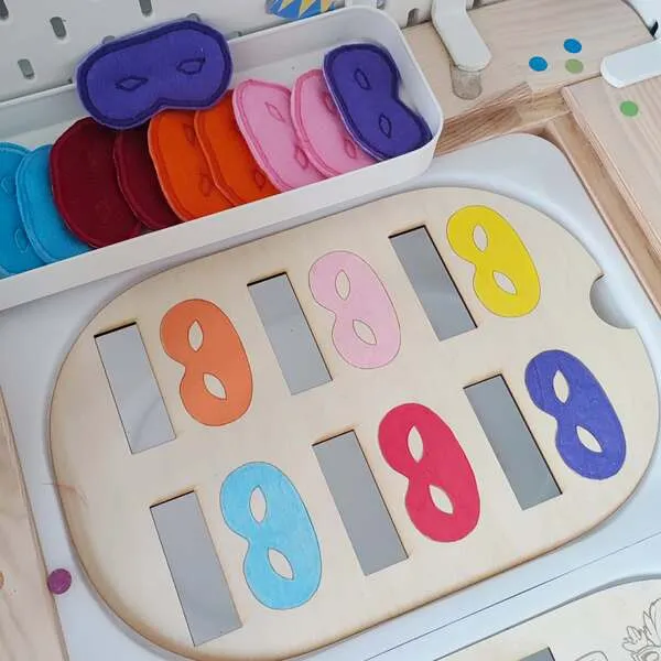 Plateau éducatif en bois avec chiffres colorés et masques de carnaval en feutrine pour activité de tri et de motricité fine