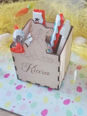 Boîte en bois personnalisée avec prénom gravé et motif lionceau, remplie de chocolats de Pâques sur une table décorée