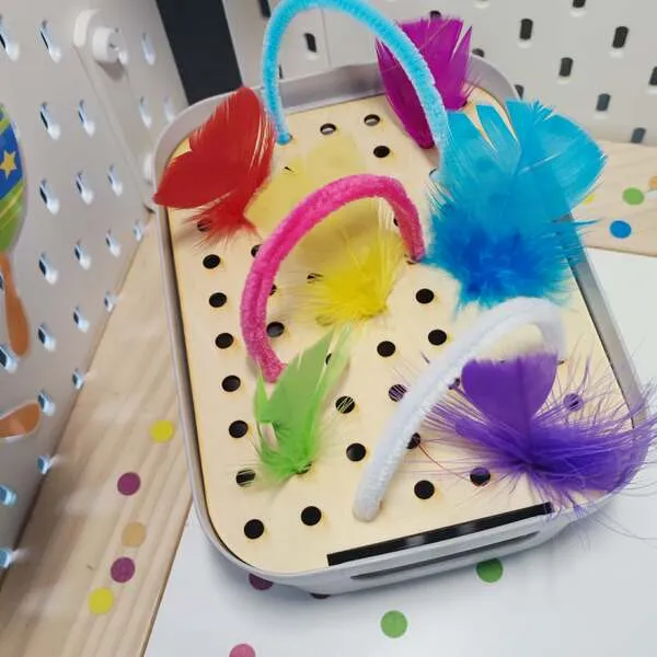 Plateau de motricité fine en bois avec plumes et chenilles colorées thème carnaval