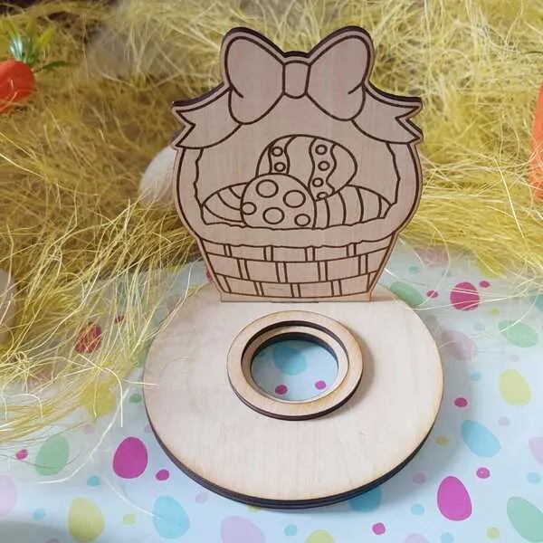 Support en bois pour œuf de Pâques représentant un panier gravé avec œufs décorés et grand nœud, posé sur socle rond avec emplacement central.