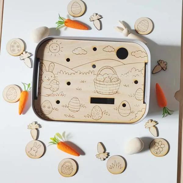 Insert éducatif en bois thème Pâques avec lapin, œufs et jetons pour activité de motricité fine.