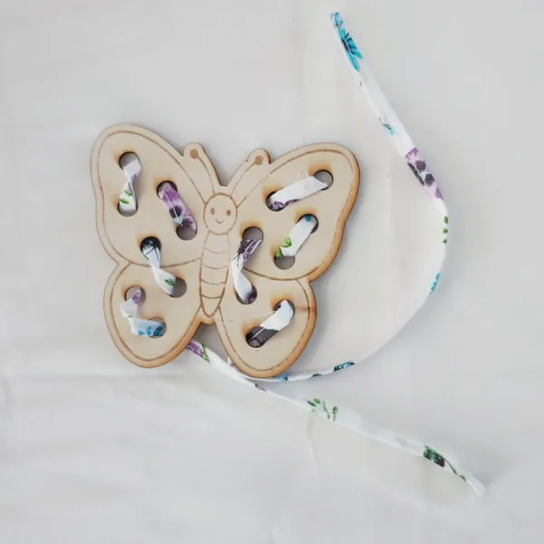 Carte à lacets papillon en bois avec lacet pour activité de motricité fine enfant.