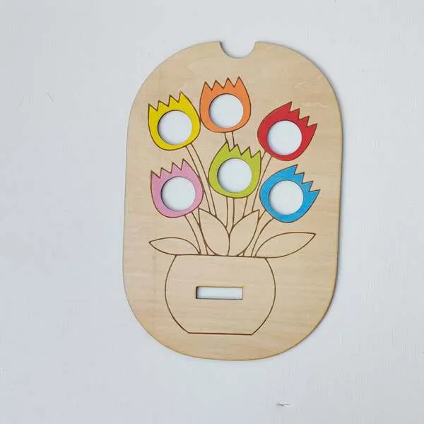 Plateau en bois fleurs colorées avec emplacements circulaires pour activité de tri.