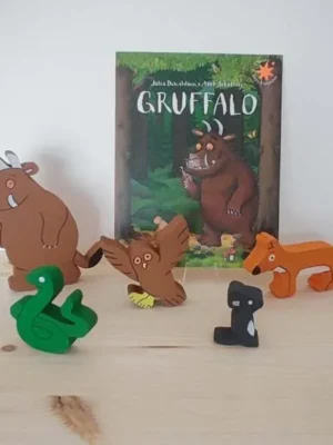 Figurines en bois du Gruffalo avec le livre en arrière-plan.