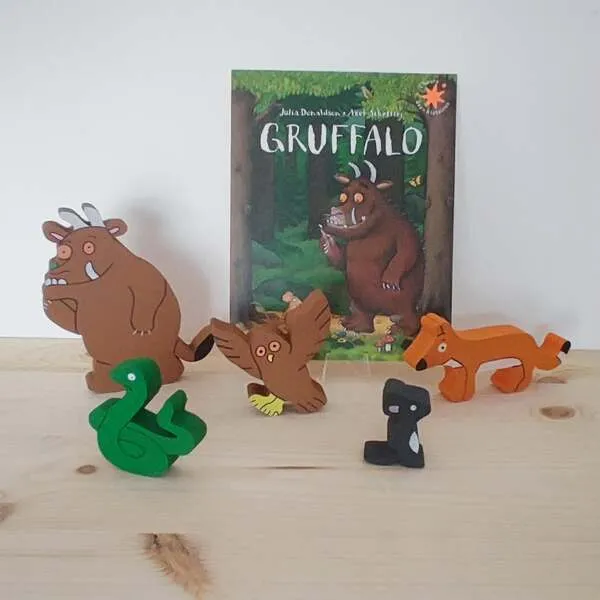 Figurines en bois du Gruffalo avec le livre en arrière-plan.