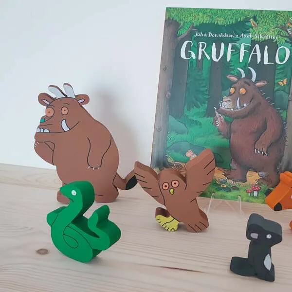 Figurines en bois du Gruffalo avec serpent, hibou et souris devant le livre.