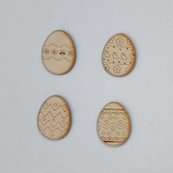 Jetons œufs de Pâques en bois gravés avec différents motifs.