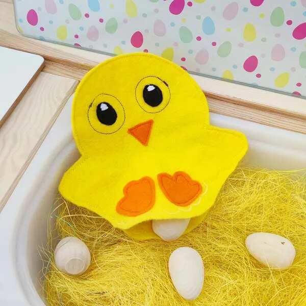 Poussin en feutrine avec poche pour cacher des œufs dans un bac sensoriel de Pâques.