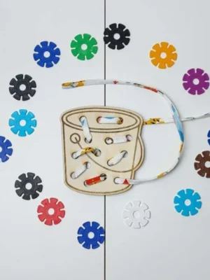 Carte à lacer tambour en bois avec lacet et jetons colorés pour activité de motricité fine.