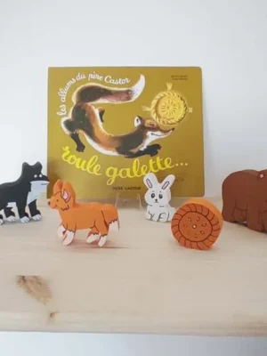 Figurines en bois Roule galette avec animaux et galette devant le livre.