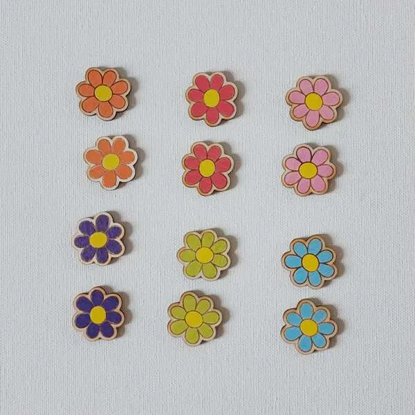 Jetons fleurs en bois colorées alignées pour activité de tri et reconnaissance des couleurs.