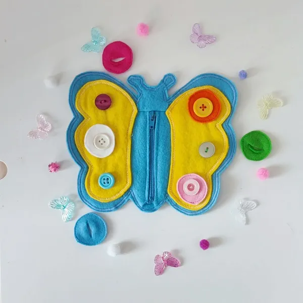Papillon en feutrine activité motricité fine enfant avec boutons et fermeture éclair.