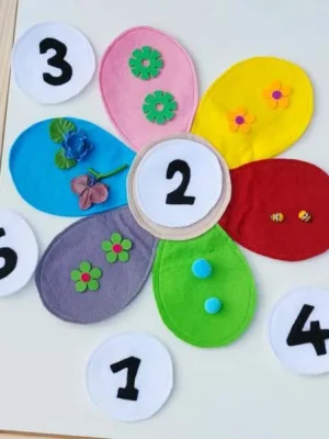 Fleur en feutrine colorée avec pétales décorés et chiffres pour activité de dénombrement.