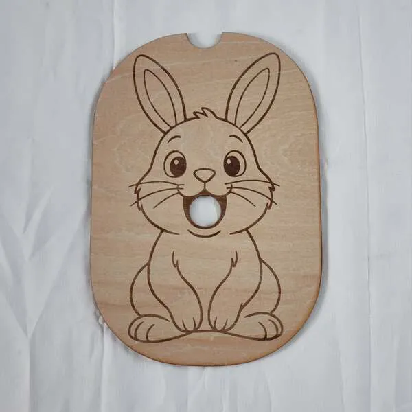 Insert en bois gravé avec un lapin de Pâques pour activité sensorielle enfant.